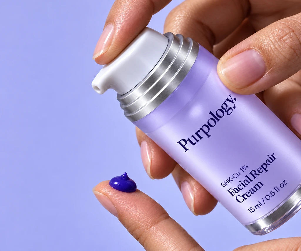 Rich violet Purpology cream dispensed onto a fingertip from the lavender Facial Repair Cream pump.